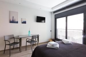 a bedroom with a bed and a table and chairs at 12 Reasons Why Metaxourgeio in Athens