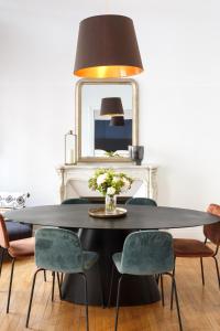 a dining room with a table with chairs and a mirror at Appartement Monceau in Paris