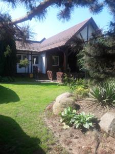 a house with a grassy yard with a tree at Apartament Reda z prywatną sauną in Reda