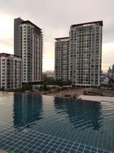 a swimming pool on the roof of a building with two tall buildings at Apartment at Punnawithi BTS in Bangkok