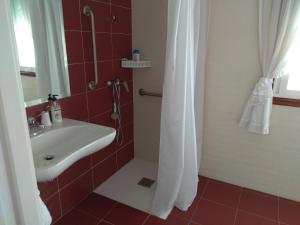 a bathroom with a sink and a shower with red tiles at Casa Rodiño in Meaño