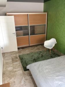 瑪美亞的住宿－C&A Residence Mamaia，一间卧室配有一张床和一张白色椅子