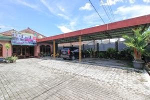 a building with a truck parked in a parking lot at RedDoorz near Candi Ratu Boko in Yogyakarta