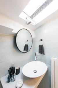 La salle de bains est pourvue d'un lavabo et d'un miroir. dans l'établissement Historic center renovated apartment- Amazing location- AC and Elevator, à Florence