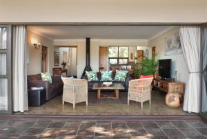 een woonkamer met een bank en stoelen bij Ama Casa Cottages in Champagne Valley