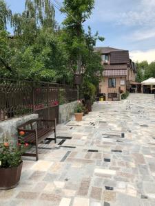 a patio with a bench and a fence and flowers at Pensiunea Calea Targovetilor in Târgovişte