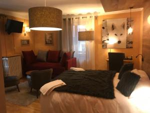 a bedroom with a bed and a living room at Auberge de la Paix in Briançon