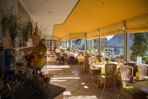 un restaurante con mesas, sillas y ventanas en Schwiizeralp Hotel & Restaurant en Stemwede