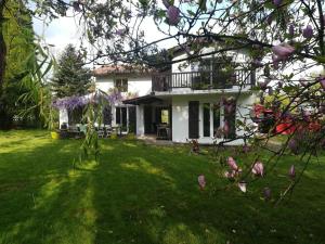 a white house with a balcony and a yard at Bizkarzuneko Etxea in Ascain