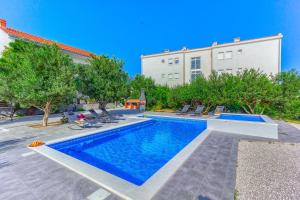 a swimming pool in front of a building at Apartment Villa Hacijenda with private pool and jacuzzi in Kaštela