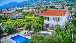 a villa with a swimming pool in a village at Apartment Villa Hacijenda with private pool and jacuzzi in Kaštela