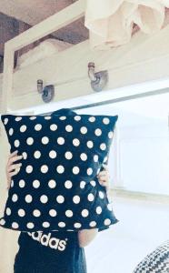 a person holding a polka dot pillow on a shelf at Jetty Huahin Hostel in Hua Hin