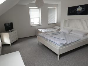 a bedroom with two beds and a tv in it at Apartment im Herzen von Neustrelitz in Neustrelitz