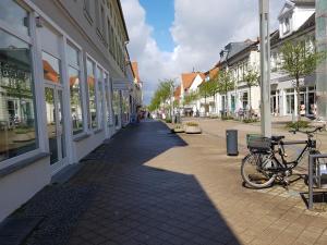 ein Fahrrad, das auf einer Straße neben einem Gebäude geparkt ist in der Unterkunft Apartment im Herzen von Neustrelitz in Neustrelitz