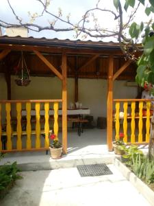 a wooden porch with a yellow fence and a table at Pensiunea Casa Vulkan in Ocna Sibiului