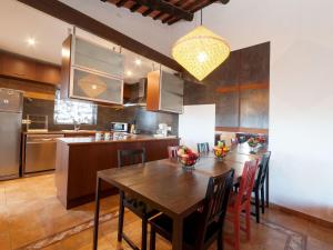 a kitchen with a wooden table and a dining room at Holiday Home Mas Ambros by Interhome in Calonge