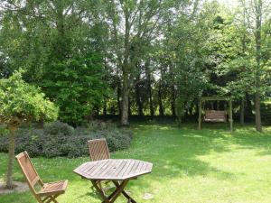 a picnic table and two chairs in a yard at Holiday Home Les Londes by Interhome in Crouay