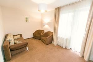a living room with two chairs and a window at Hotel International in Baile Felix