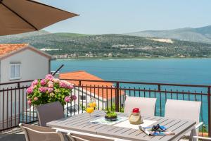 una mesa en un balcón con vistas al agua en Apartments Bellezza, en Trogir