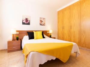 a bedroom with a large bed with a yellow blanket at Holiday Home 2 Casas by Interhome in Riumar