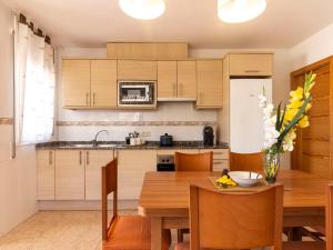 Holiday Home 3 Casas by Interhome في ريومار: مطبخ بدولاب خشبي وطاولة خشبية