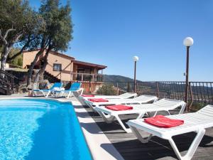 a row of lounge chairs next to a swimming pool at Holiday Home Mas Ambros by Interhome in Calonge