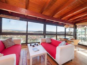 a living room with red couches and a table at Holiday Home Mas Ambros by Interhome in Calonge