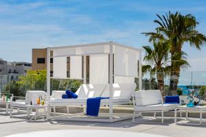 un grupo de sillas y mesas blancas en una azotea en Hotel Vibra Mare Nostrum, en Playa d'en Bossa