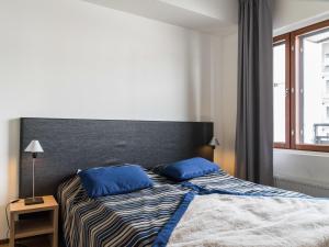 a bedroom with a bed with blue pillows on it at Holiday Home Nordic chalet 9408 by Interhome in Ylläs