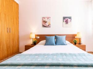 1 dormitorio con 1 cama grande con almohadas azules en Holiday Home 3 Casas by Interhome, en Riumar