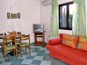 a living room with a couch and a table and a tv at Holiday Home Ana-2 by Interhome in Vir