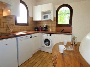 a kitchen with a washing machine and a wooden table at Holiday Home Le Fournil by Interhome in Mimizan