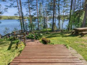 un chemin en bois menant à un lac avec un banc dans l'établissement Holiday Home Lehtimaja by Interhome, à Tiitanvaara