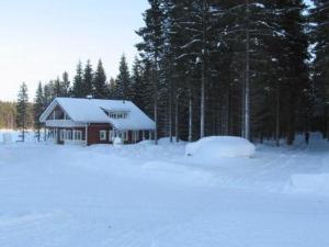 a cabin in the snow in a field with trees at Holiday Home Arhippa by Interhome in Kurkimaki