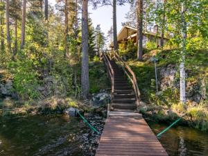 un pont en bois sur une rivière en face d'une maison dans l'établissement Holiday Home Lehtimaja by Interhome, à Tiitanvaara