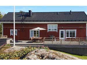 une maison rouge avec une table et un parasol dans l'établissement Holiday Home Villa pääsky by Interhome, à Karuna