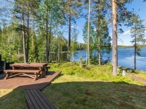 a picnic table on a deck with a view of a lake at Holiday Home Pajulintu by Interhome in Tiitanvaara