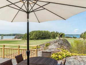 une table avec un parasol sur une terrasse dans l'établissement Holiday Home Villa pääsky by Interhome, à Karuna