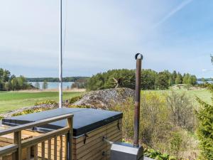 a deck with a table and a bird flying over the water at Holiday Home Villa pääsky by Interhome in Karuna