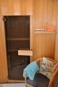 a glass cabinet with a chair in a room at Ferienwohnung Fischer in Frickingen