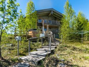 una casa de madera con escaleras que conducen a ella en Holiday Home Villa pyöriäinen by Interhome, en Pihlajaniemi