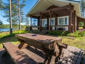 a large wooden picnic table in front of a house at Holiday Home Pajulintu by Interhome in Tiitanvaara