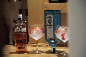 two wine glasses and a bottle of alcohol on a table at Alcester Inn in Alcester