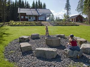 a woman and a child playing in a garden at Holiday Home Arhippa by Interhome in Kurkimaki