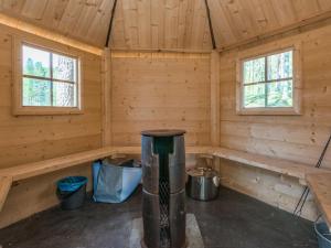 a log cabin with two windows and a stove in it at Holiday Home Patu by Interhome in Pihlajaniemi