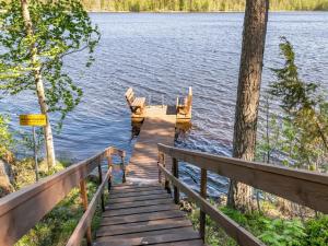 une rampe en bois menant à un quai sur un lac dans l'établissement Holiday Home Lehtimaja by Interhome, à Tiitanvaara