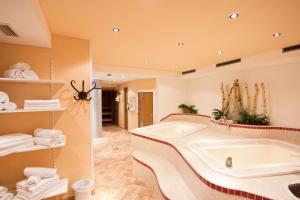 uma grande casa de banho com banheira e toalhas em Hotel Garni Hainbacherhof em Sölden