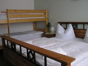 a bedroom with two bunk beds with white sheets at Waldhotel Seelow in Seelow