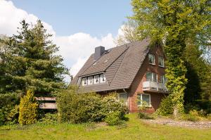 une maison en briques avec un toit en gambrel dans l'établissement Undeloher Hof, à Undeloh