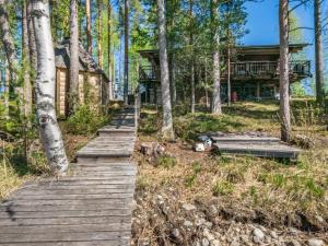 a wooden path leading to a cabin in the woods at Holiday Home Patu by Interhome in Pihlajaniemi